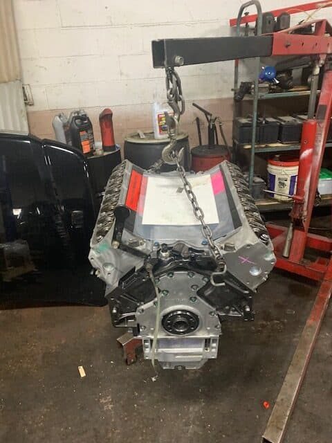 Engine block lifted on a hoist in the workshop